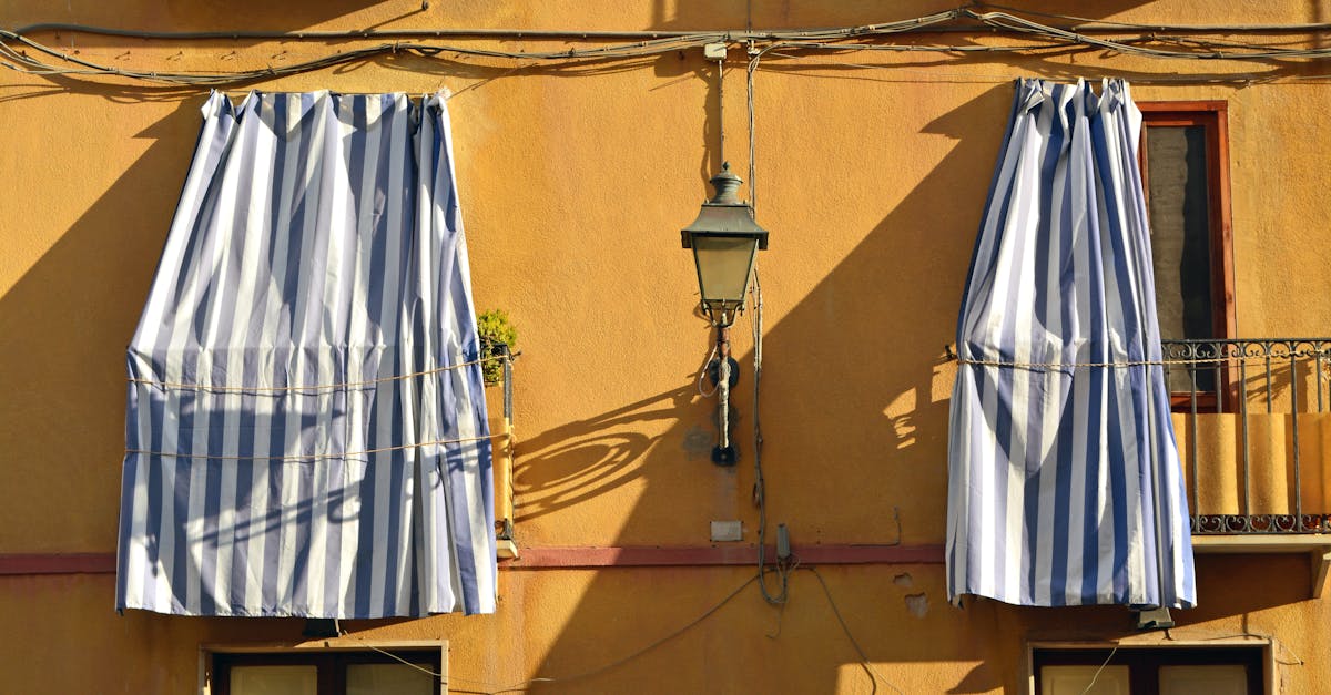 Charming facade in Sicily featuring striped awnings and vibrant colors.