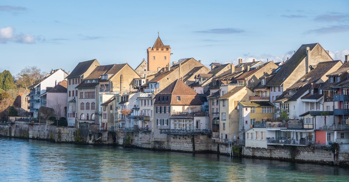 Scenic view of traditional European architecture by the river on a sunny day.