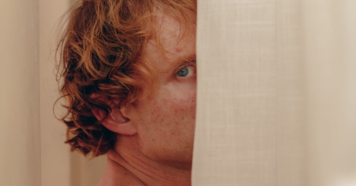 A person peeking out from behind a curtain, creating a sense of mystery and intrigue.