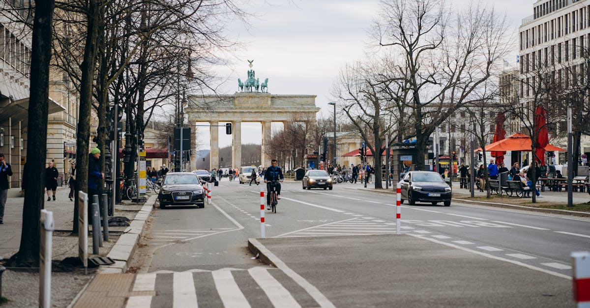 Street scene with Brandenburg Gate in Berlin, showcasing urban life and historic architecture.