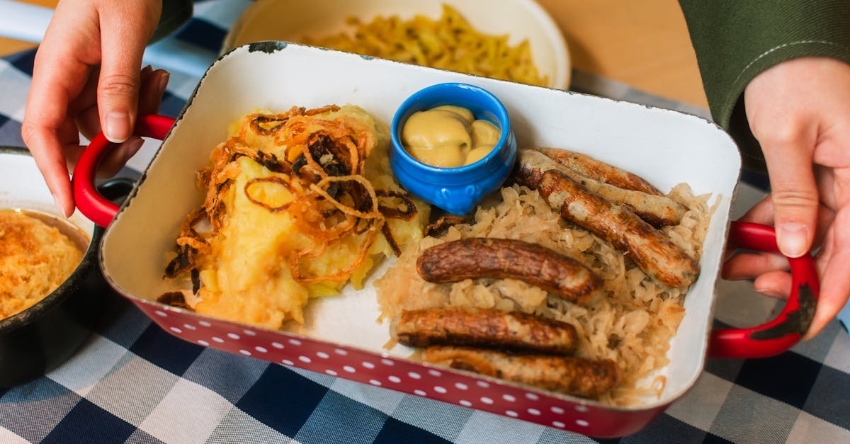 A rustic platter with sausages, sauerkraut, mustard, and mashed potatoes, perfect for hearty meals.