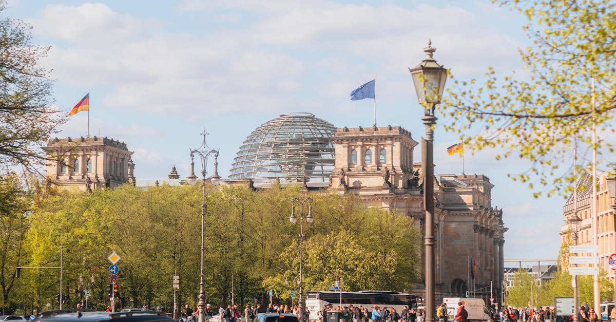 A vibrant street view of the Reichstag in Berlin, Germany, featuring bustling city life and iconic architecture.
