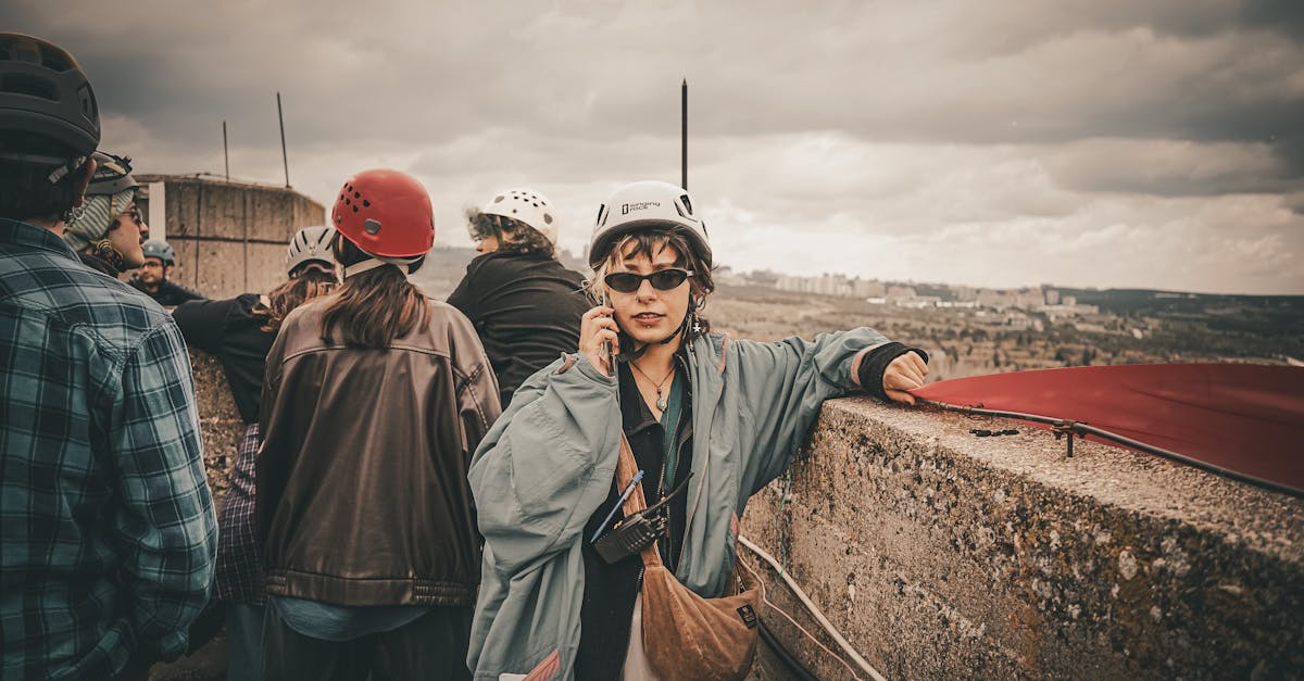 Group of adults on a rooftop tour, wearing helmets, capturing urban exploration adventure.