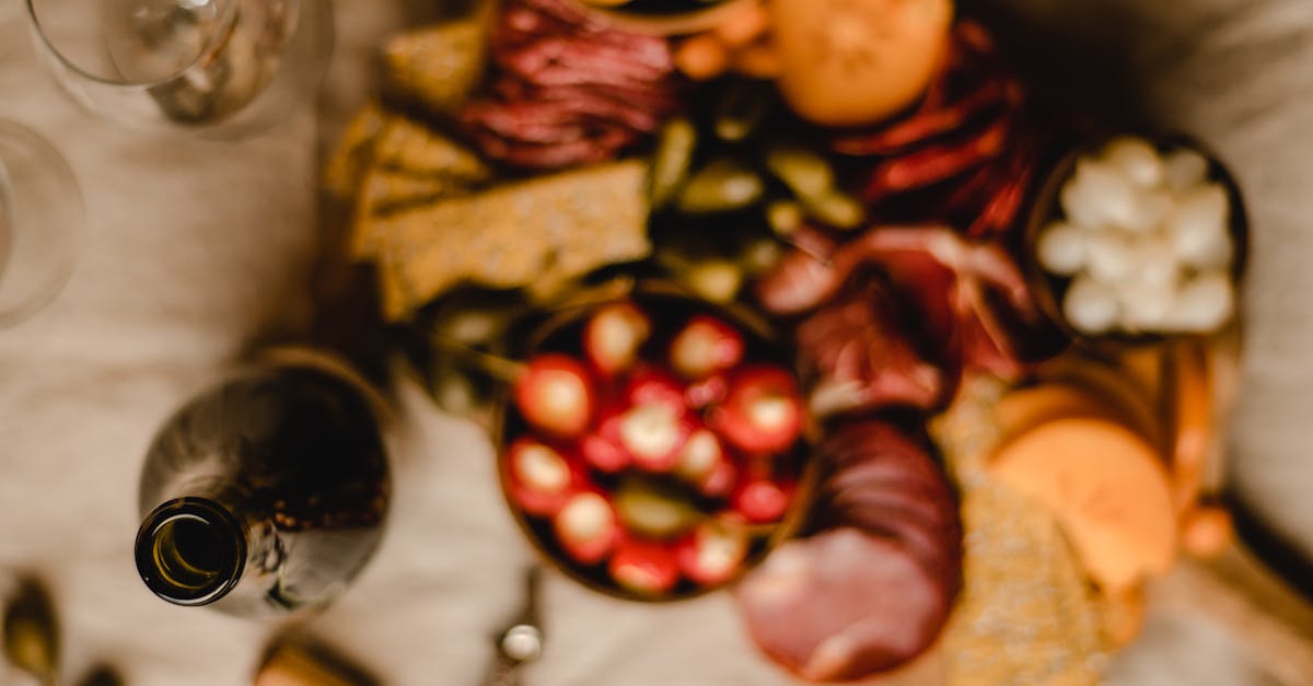 A vibrant charcuterie board filled with meats, cheeses, and olives paired with a bottle of red wine.