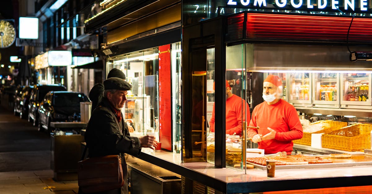 Colorful street food vendor at night in Vienna's bustling city streets, featuring neon lights and engaging interactions.