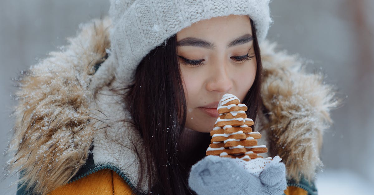 Close-up of a woman savoring the scent of Christmas cookies in winter attire.