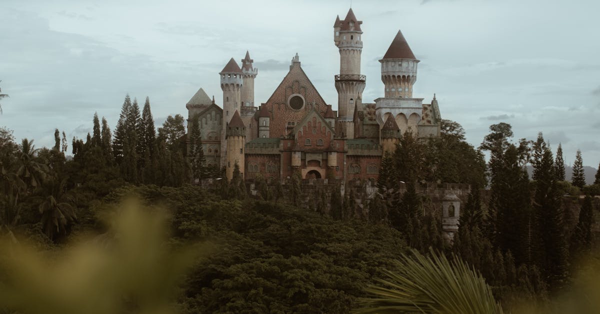 Fairytale-inspired castle nestled in Batangas, surrounded by verdant trees under a cloudy sky.