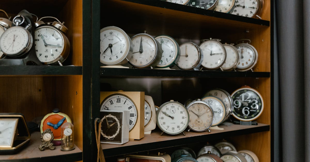 A variety of vintage alarm clocks displayed on wooden shelves, evoking nostalgia.
