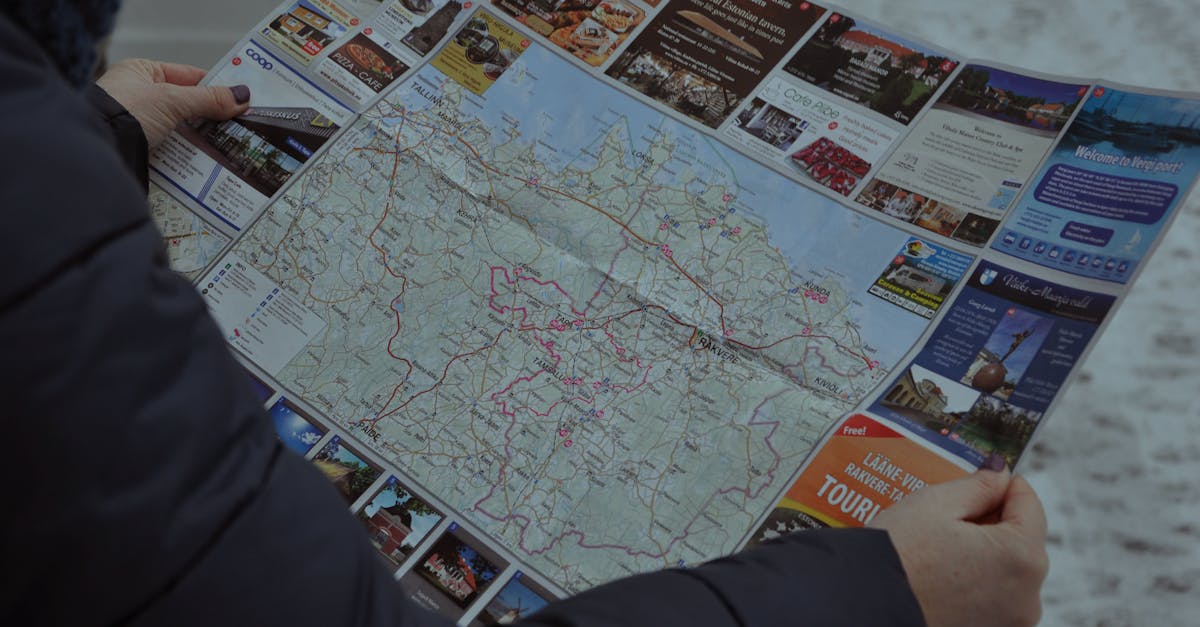 A person examining a detailed map outside during winter, focusing on directions.