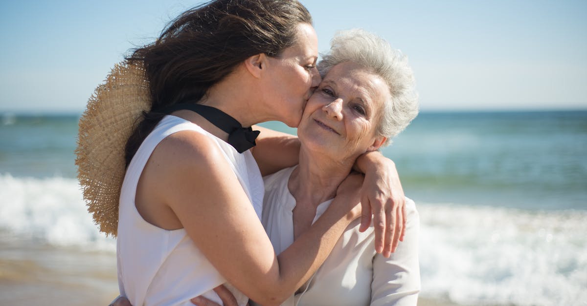 A touching moment of love as a mother and daughter embrace on a sunny beach.