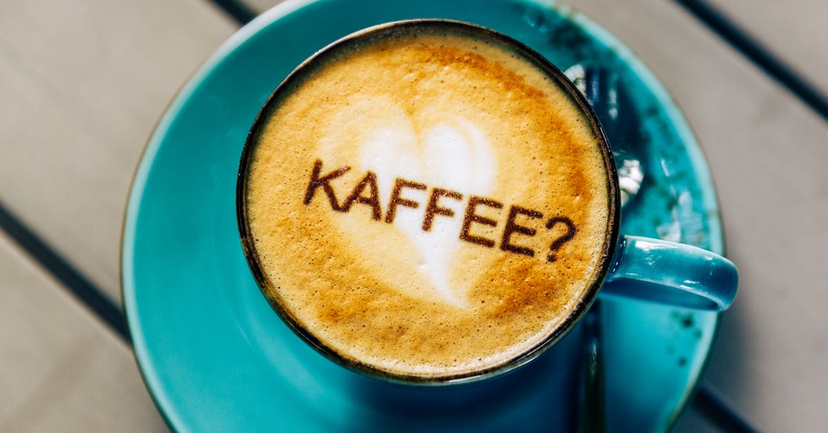 Heart-shaped latte art on cappuccino with a playful 'KAFFEE?' text in Osnabrück.