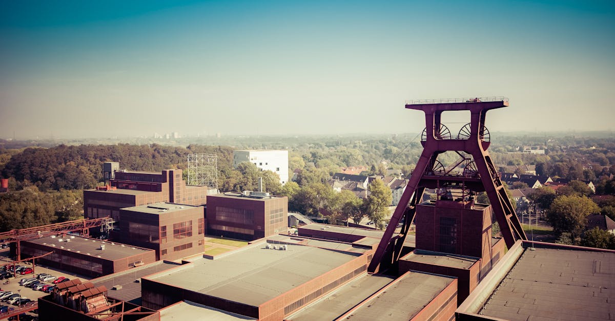 Aerial view of a coal mining plant surrounded by greenery, showing industrial architecture.