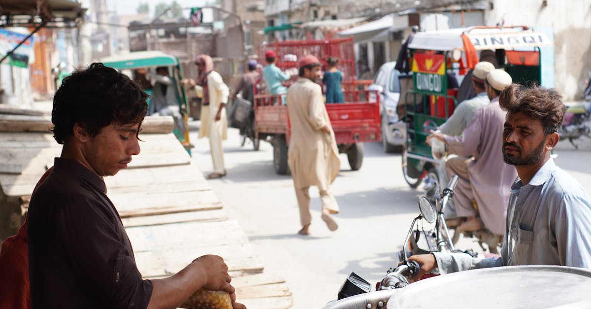 Street vendor selling food in bustling Nowshera, Pakistan. Urban life depicted with locals.